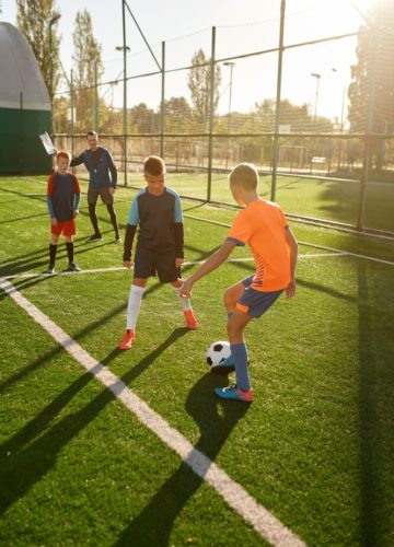 young-boys-playing-football-soccer-match-at-training-camp-for-kids